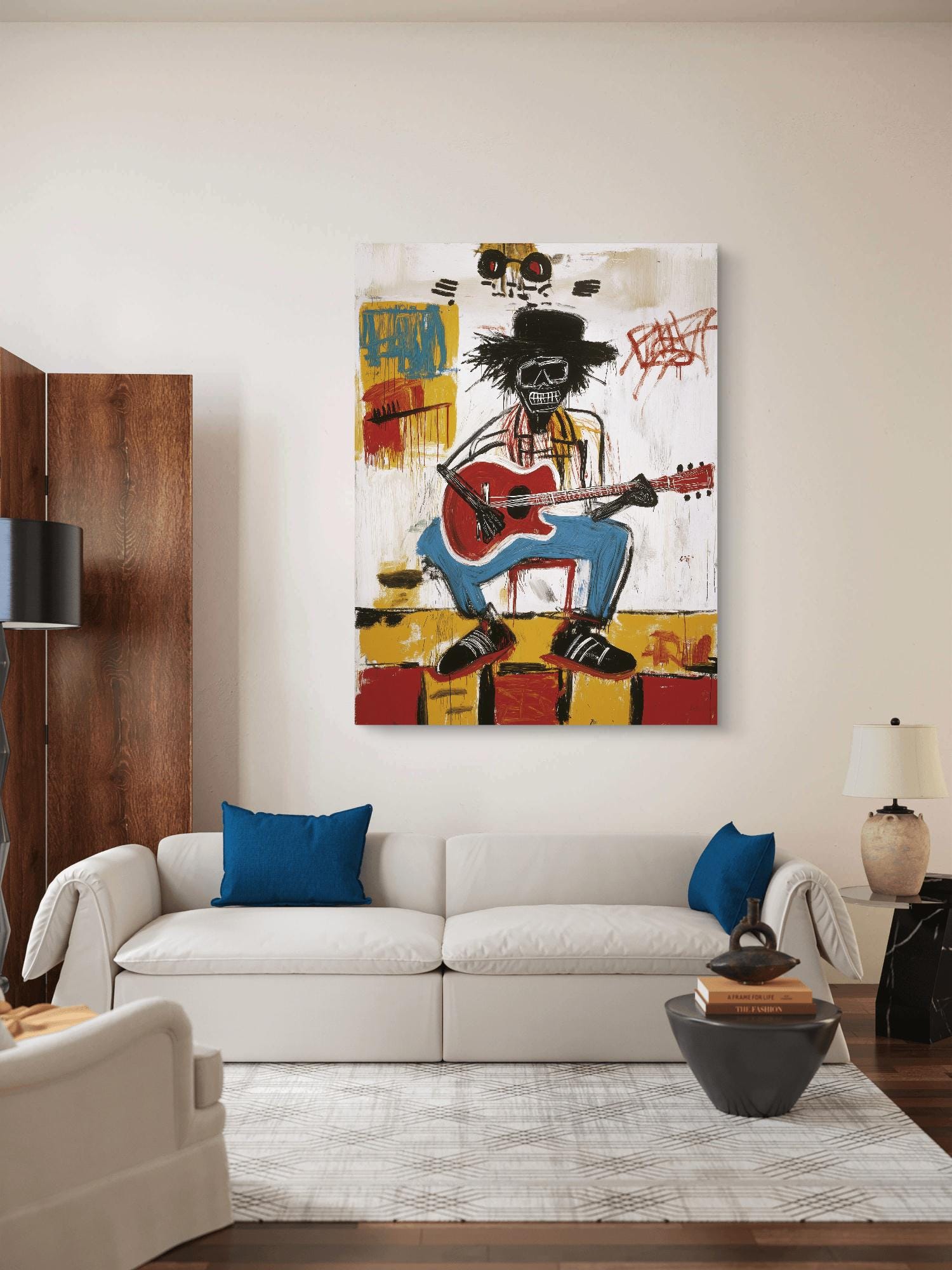 Living room with a white sofa, blue pillows, and a colorful painting of a skeleton playing guitar on the wall.