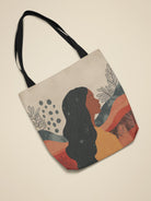 Afrocentric tote bag with abstract silhouette and the words “Peace Be Still,” made from durable polyester with natural cotton handles. Stylish and inspiring for daily use.