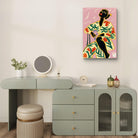 Afrocentric wall art featuring a bold woman in a floral outfit with vibrant colors on a pink background, available as a premium ready-to-hang canvas print.