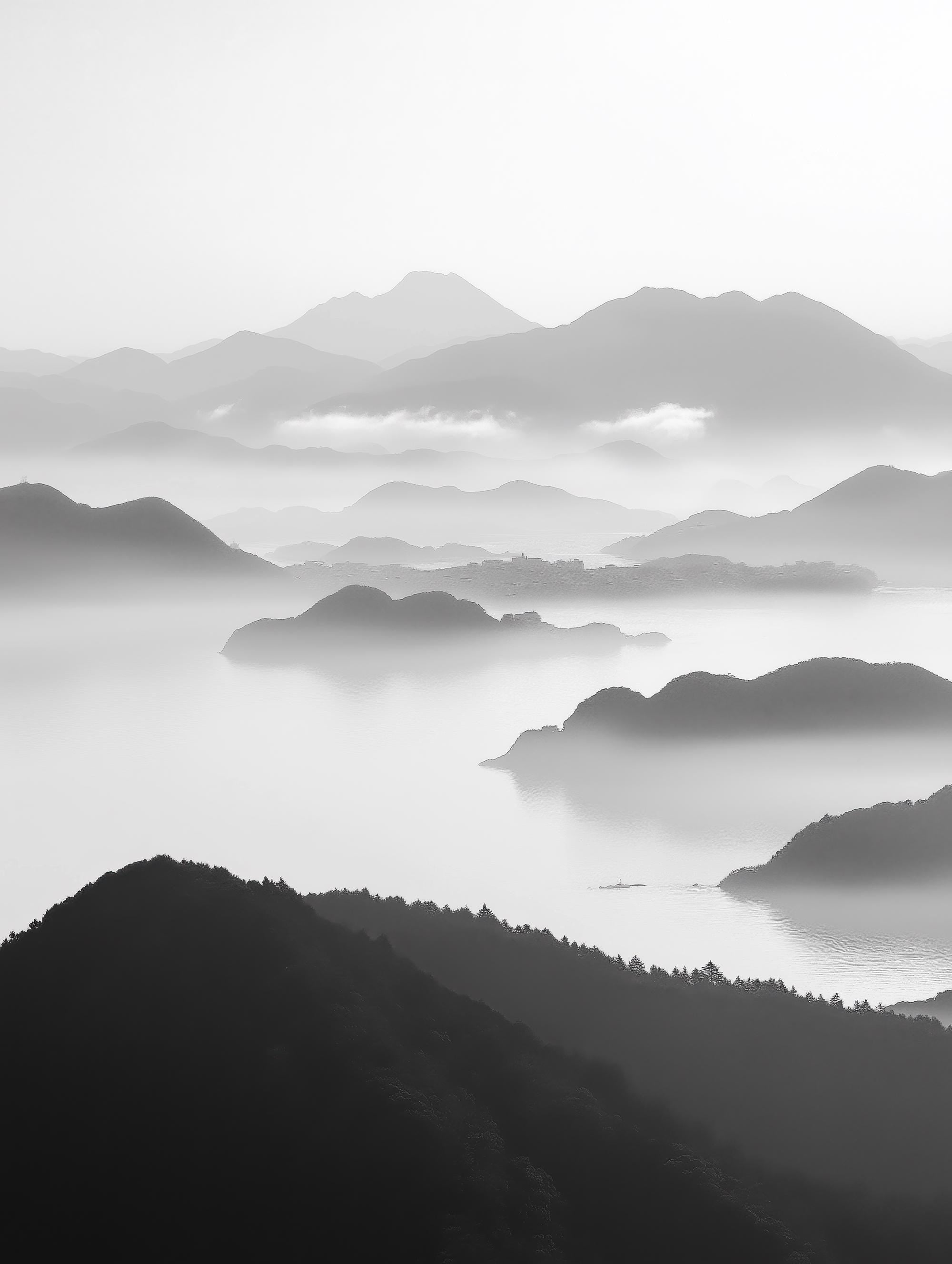 Tranquil Peaks black and white landscape print featuring mist-covered mountains and serene waters, available as a canvas or fine art paper print.