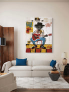 Living room with a white sofa, blue pillows, and a colorful painting of a skeleton playing guitar on the wall.